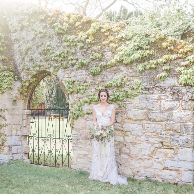 Bride in Stephanie Allin Floral Wedding Dress Standing in Romantic Walled Garden