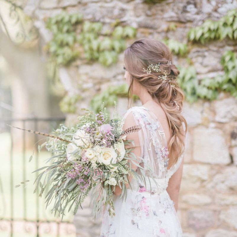 Bride in Stephanie Allin Floral Wedding Dress Holding Romantic White and Lilac Wedding Bouquet with Foliage