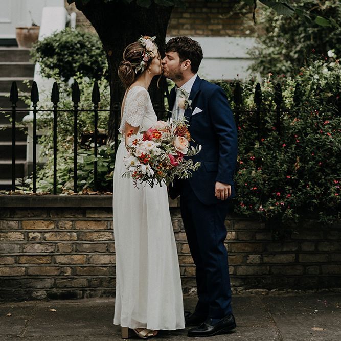 Bride in lace bridal gown  with bright flowers and flower crown
