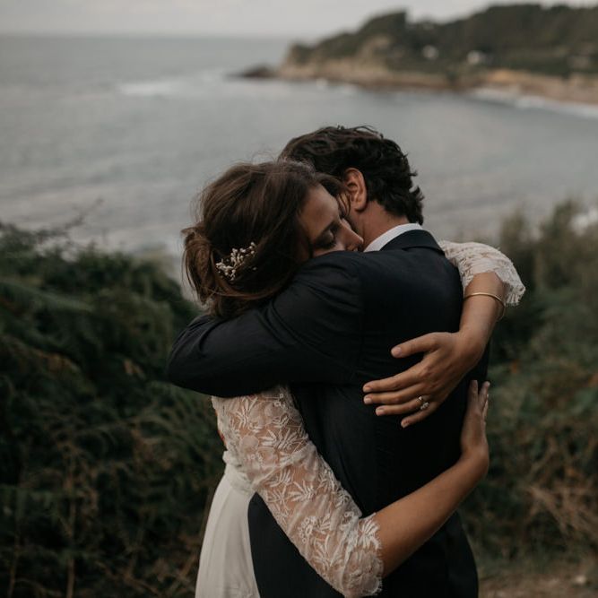 Bride in Donatelle Godart Wedding Dress &amp; Groom in De Fursac Suit  Embracing by the Coast
