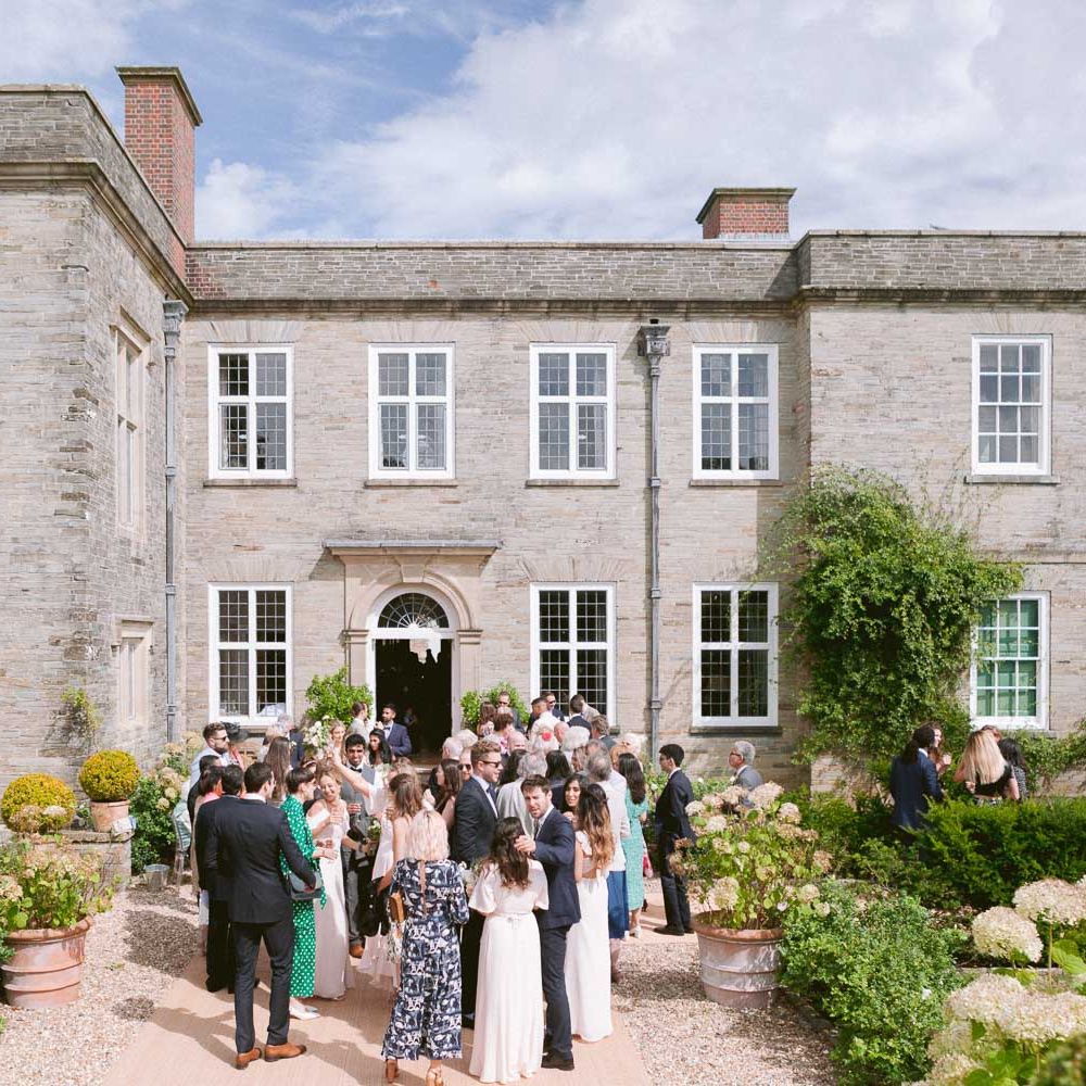 Guests enjoy a drink out Shilstone House wedding venue in Devon