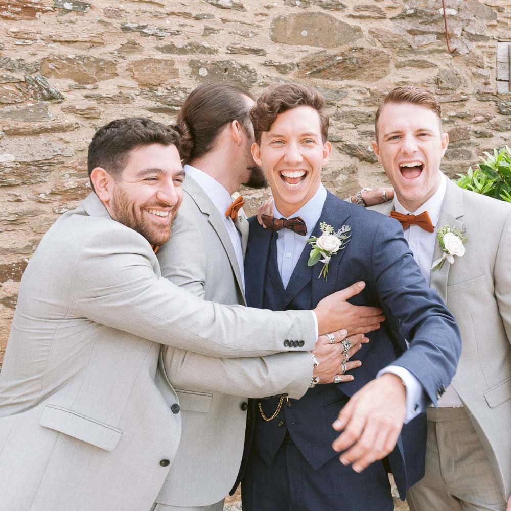 Groomsmen wear light suits with matching bowties