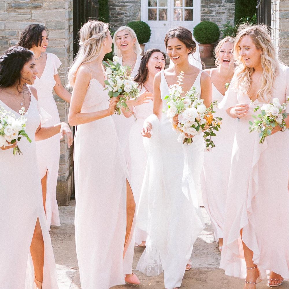 Bridesmaids in pink dresses with bride in simple wedding dress