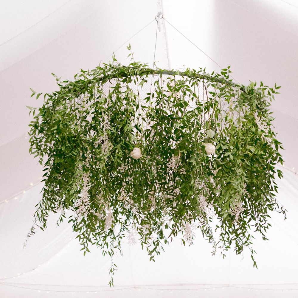 Foliage chandelier hanging above dinner reception
