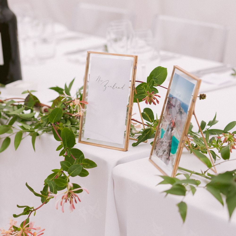 Wedding table decor with foliage and photo frames
