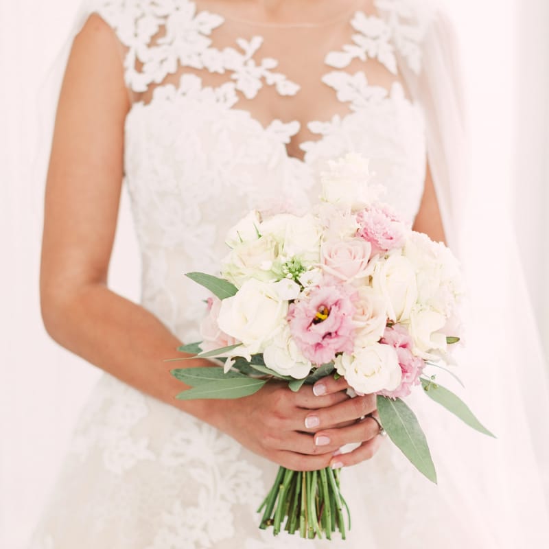 Bride in Lace Illusion Neck Wedding Dress Holding Her Pink and White Rose Bouquet