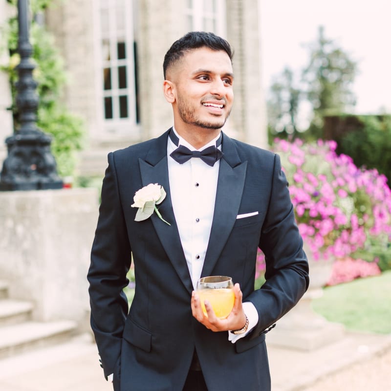 Stylish Groom in a Black Tie Suit with Bow Tie and White Flower Buttonhole