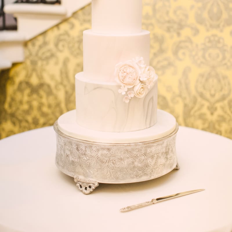 Elegant White Wedding Cake with Marble Bottom Tier and Rose Decor