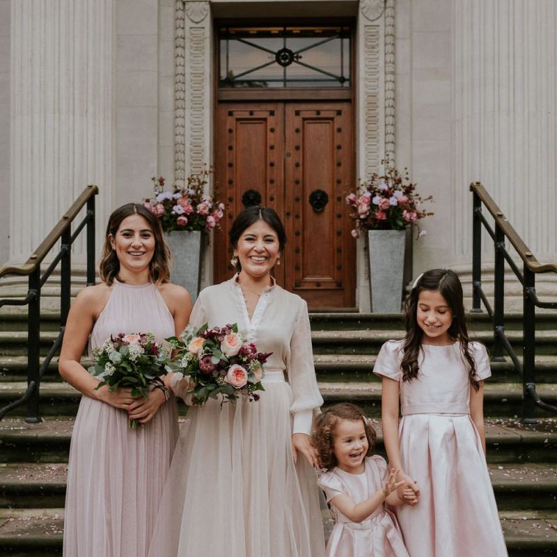 Bride and bridesmaid standing on the steps at Old Marylebone Town Hall