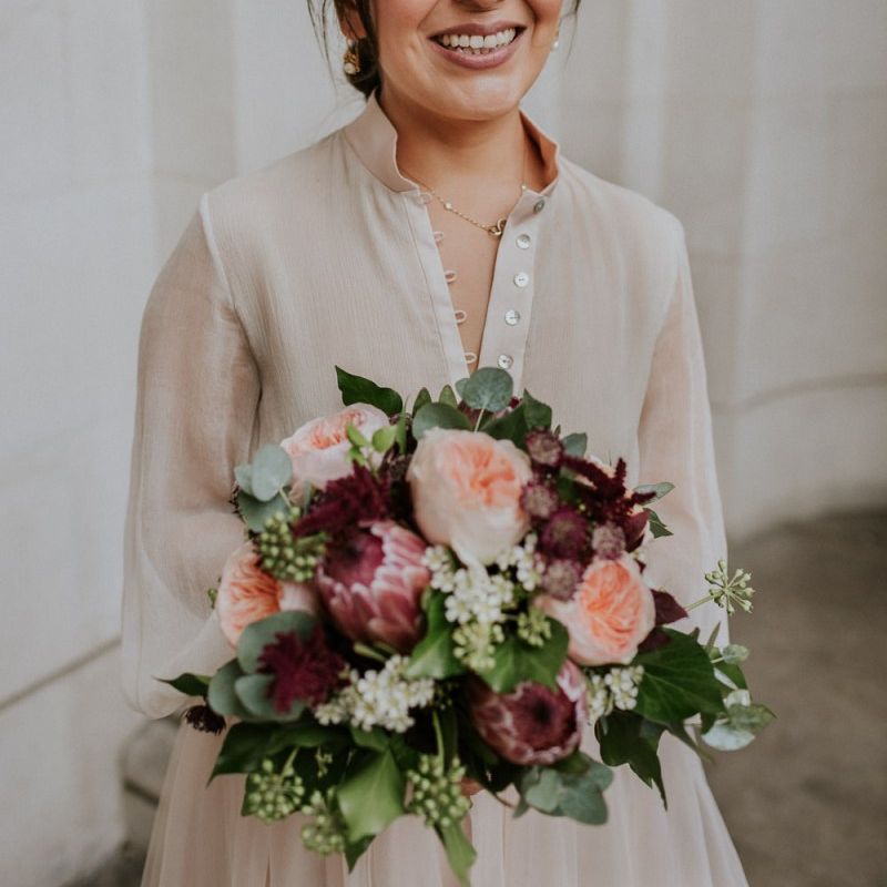 Bride holding a david austin rose and protea wedding bouquet