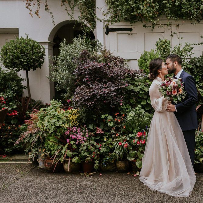 Bride and groom portraits next to some plants by Maja Tsolo Photography