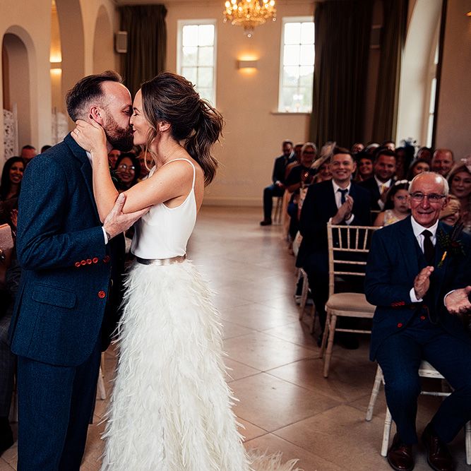 Bride in Charlie Brear Payton Bridal Gown &amp; Piora Feather Skirt and Groom in Three Piece Wool Suit