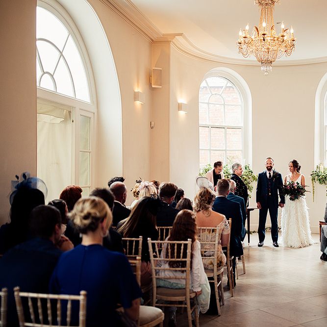 Bride in Charlie Brear Payton Bridal Gown &amp; Piora Feather Skirt and Groom in Three Piece Wool Suit