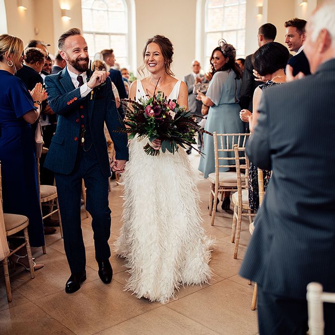 Bride in Charlie Brear Payton Bridal Gown &amp; Piora Feather Skirt and Groom in Three Piece Wool Suit