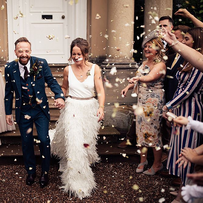 Confetti Moment with Bride in Charlie Brear Payton Bridal Gown &amp; Piora Feather Skirt and Groom in Three Piece Wool Suit