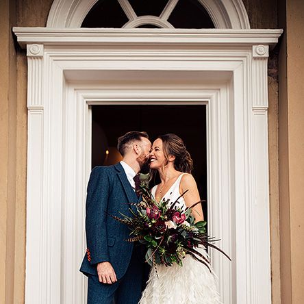Bride in a Charlie Brear Payton Bridal Gown &amp; Piora Feather Skirt and Groom in a Navy Suit