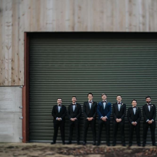 Groom wearing navy velvet suit with his groomsmen for New Years eve ceremony