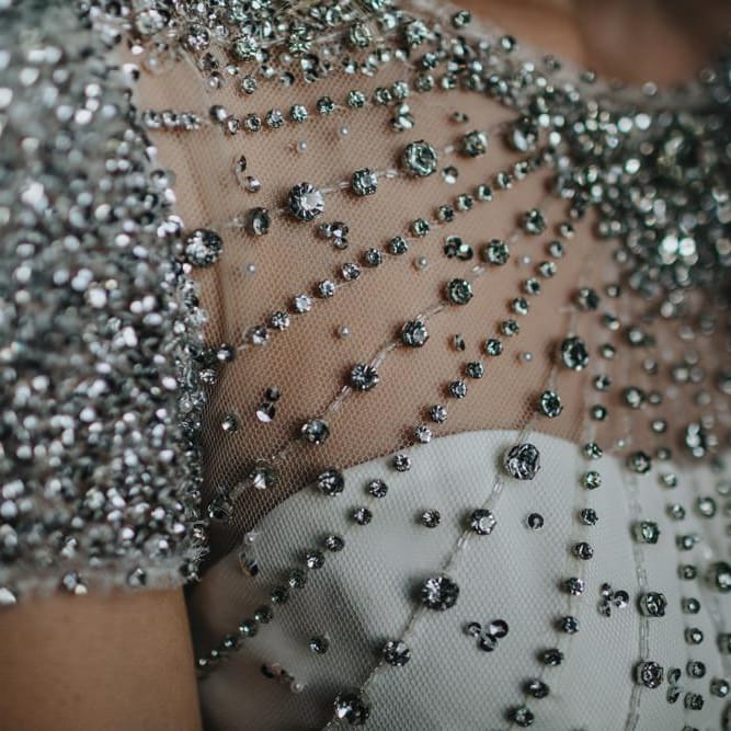 Close up details of brides embellished wedding dress for black tie New Years eve wedding with sparkles and glamour