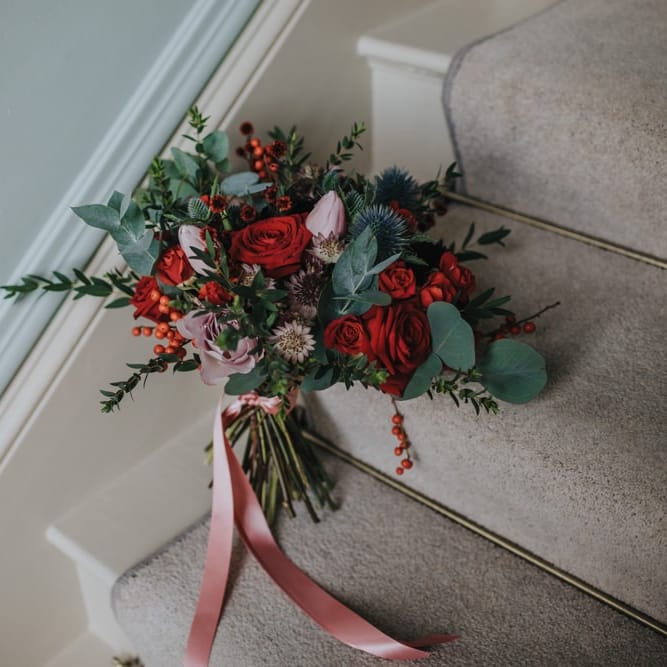 Red festive themed floral bouquet for winter wedding