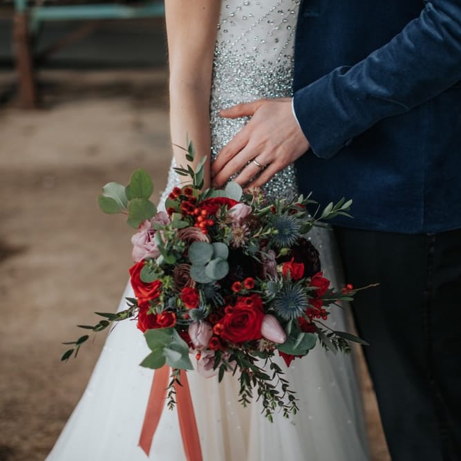 Close up details of winter inspired floral bouquet with red roses at New Years eve celebration