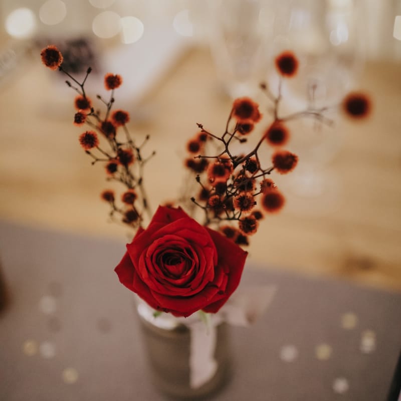 Red rose floral table decor at winter reception with fairy lights