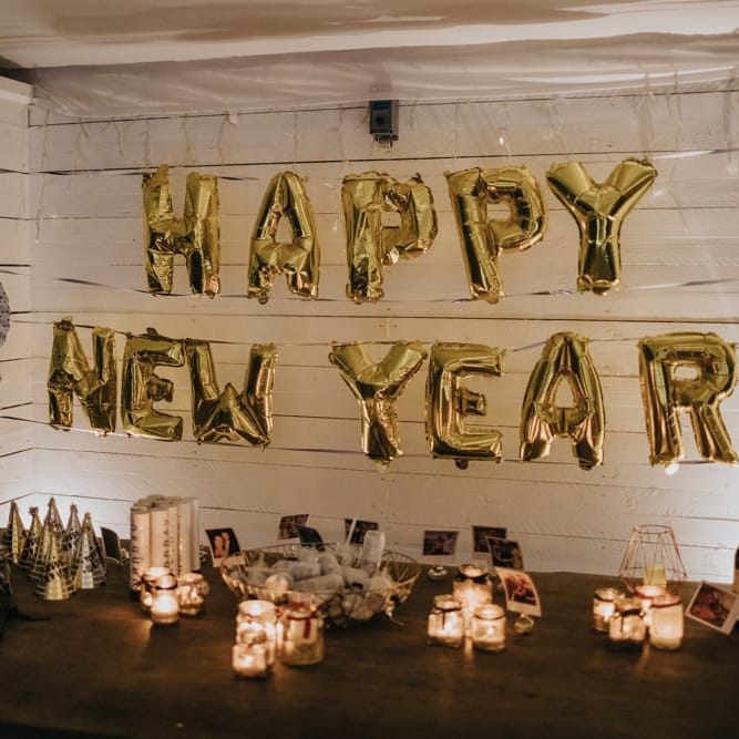 'Happy New Year' balloons for marquee winter reception with fairy lights and candles