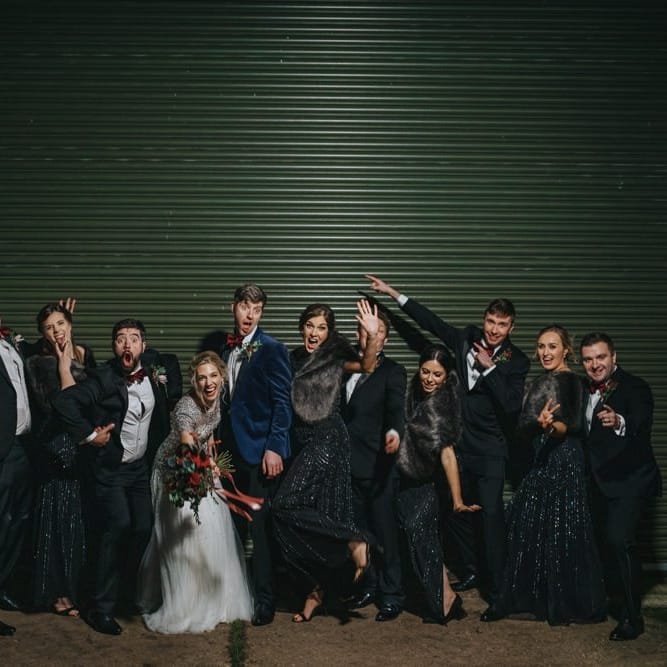 Bride and groom with  groomsmen in black tie and black bridesmaid dresses