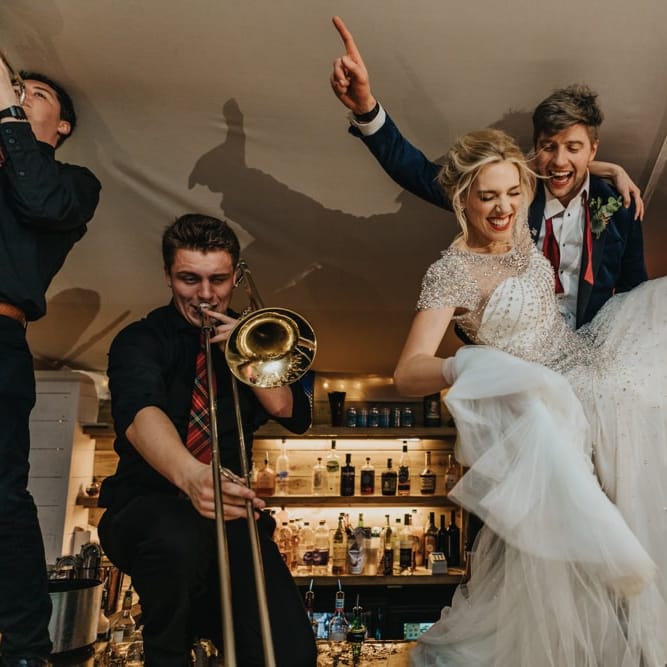 Bride and groom party into the new year dancing on the bar with their band