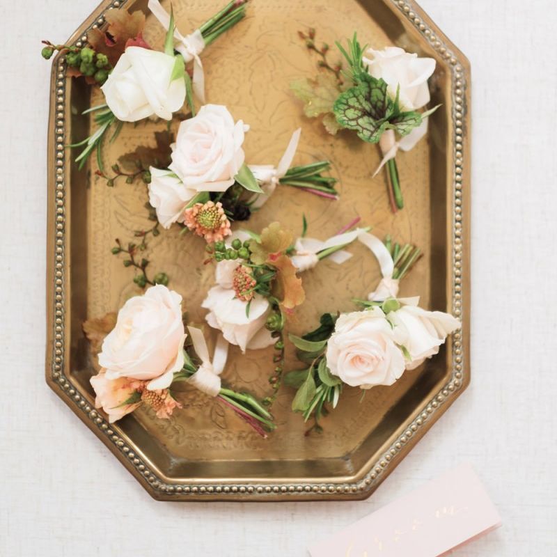 Pink rose buttonholes on gold tray