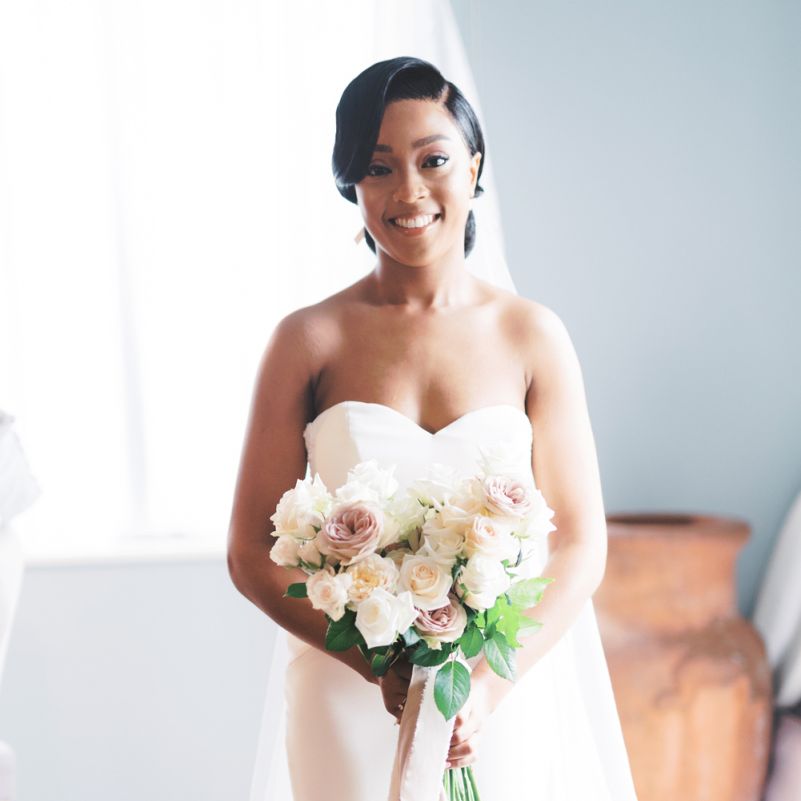 Bride in strapless Enzoani wedding dress holding her classic wedding bouquet