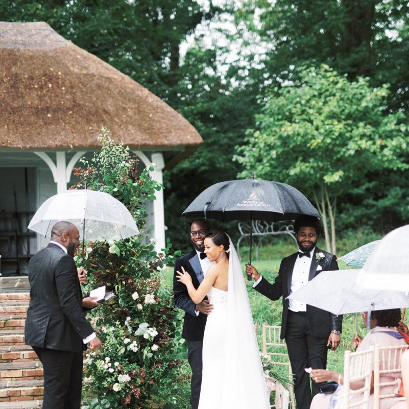 Bride and groom exchanging vows under an umbrella