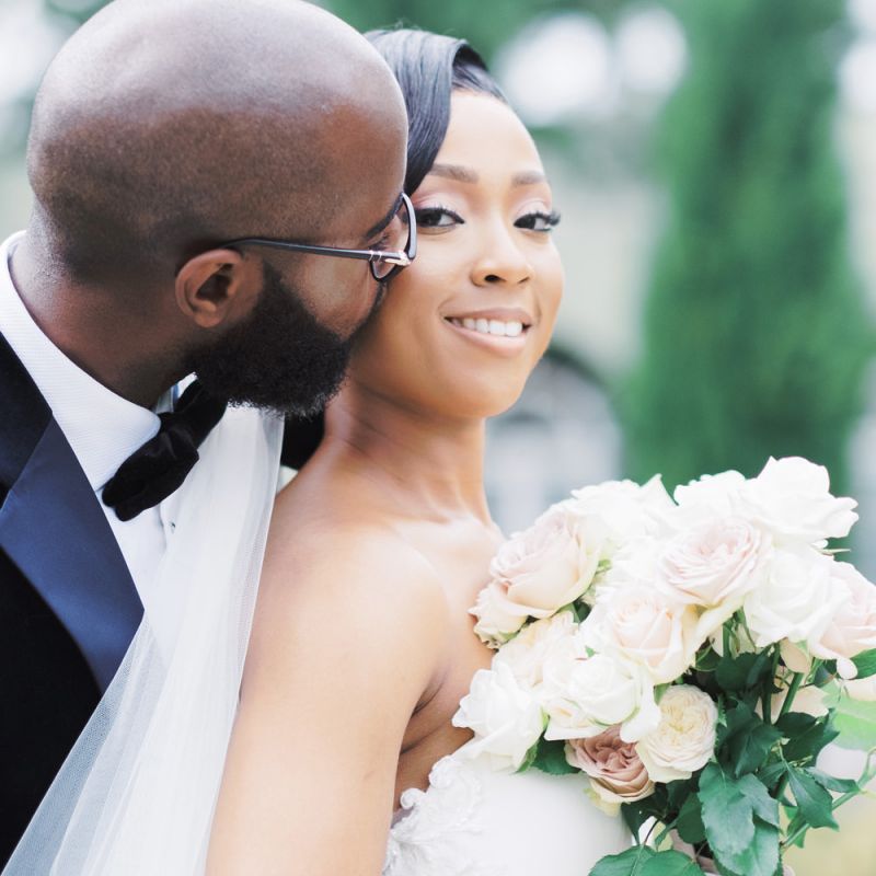 Groom kissing his brides cheek