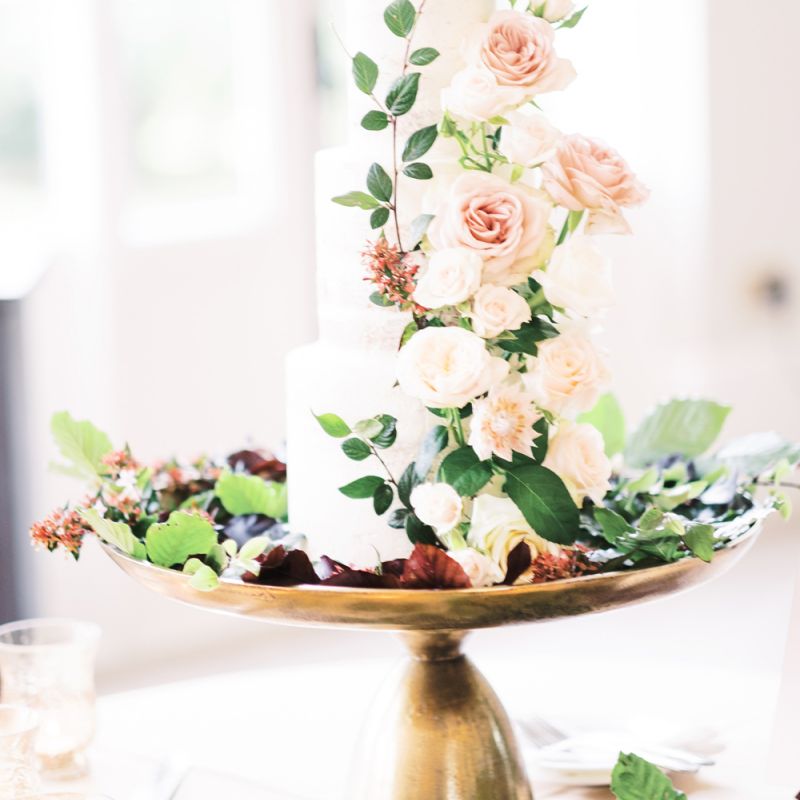 Classic wedding cake on gold cake stand decorated with flowers