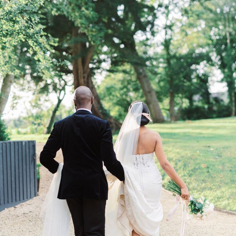 Groom helping his bride with her wedding dress train