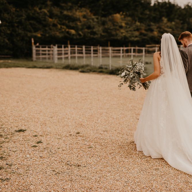 bride and groom walking through the grounds of their rustic wedding venue