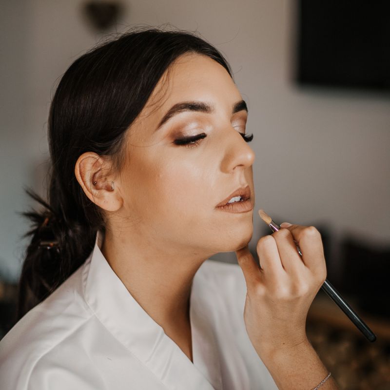 bride having her makeup done on the wedding morning