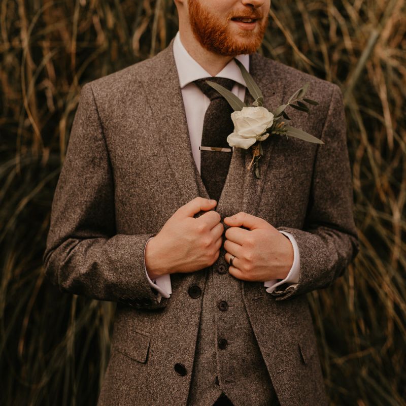 Groom in world suit for rustic wedding