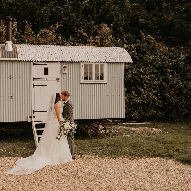 Bride and groom portrait in front of rural trailer