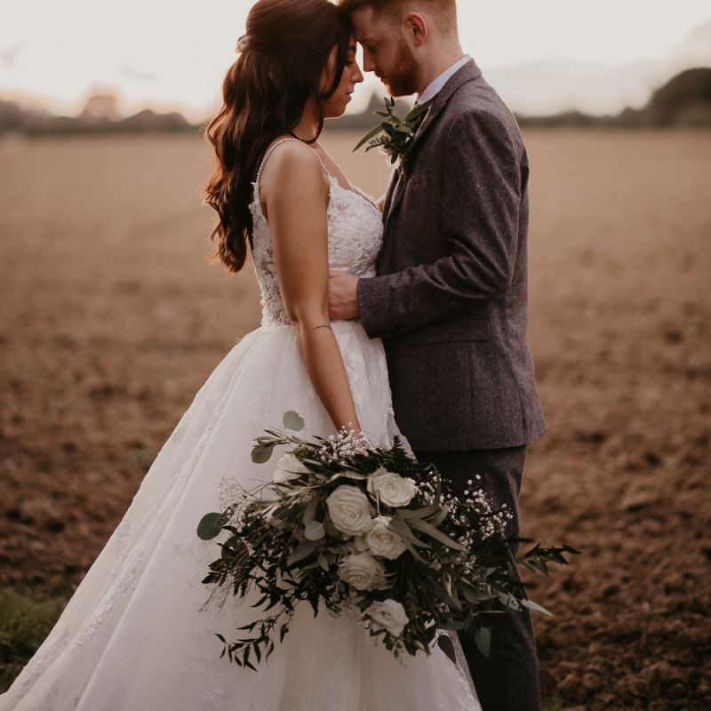 Bride and groom portrait in a field