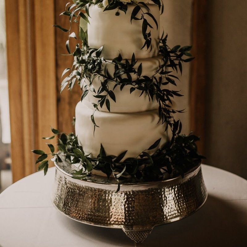 Homemade wedding cake covered in foliage