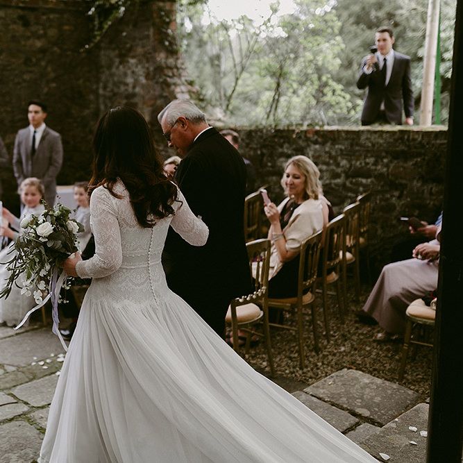 Bride Walking Down the Aisle in a Homemade Wedding Dress with Lace Bodice and Long Sleeves