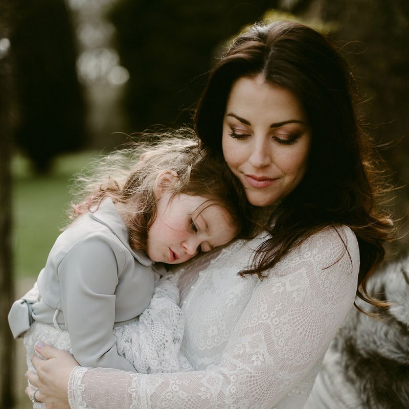 Bride in a Homemade Wedding Dress with Lace Bodice and Long Sleeves  Holding a Flower Girl