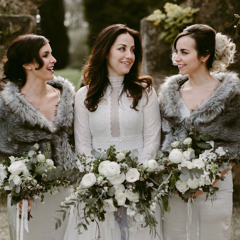 Bridal Party and Bridesmaids in Grey Satin Dresses with Fur Stoles and Bride in a Homemade Wedding Dress with Lace Bodice and Long Sleeves