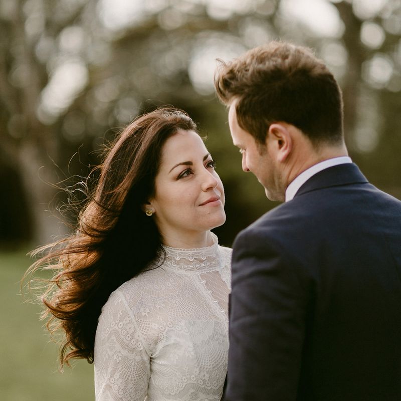 Bride in a Homemade Wedding Dress with Lace Bodice and High Neck, and Groom in Navy Suit