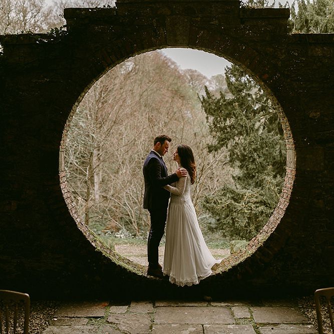 Bride in Homemade Wedding Dress with Lace Long Sleeves and High Neck and Groom in Navy Zara Suit