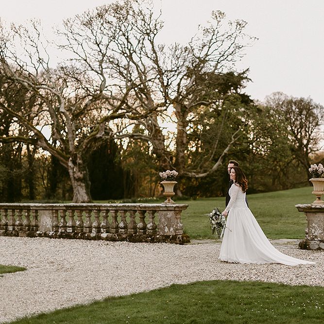 Bride in Homemade Wedding Dress with Lace Long Sleeves and High Neck and Groom in Navy Zara Suit