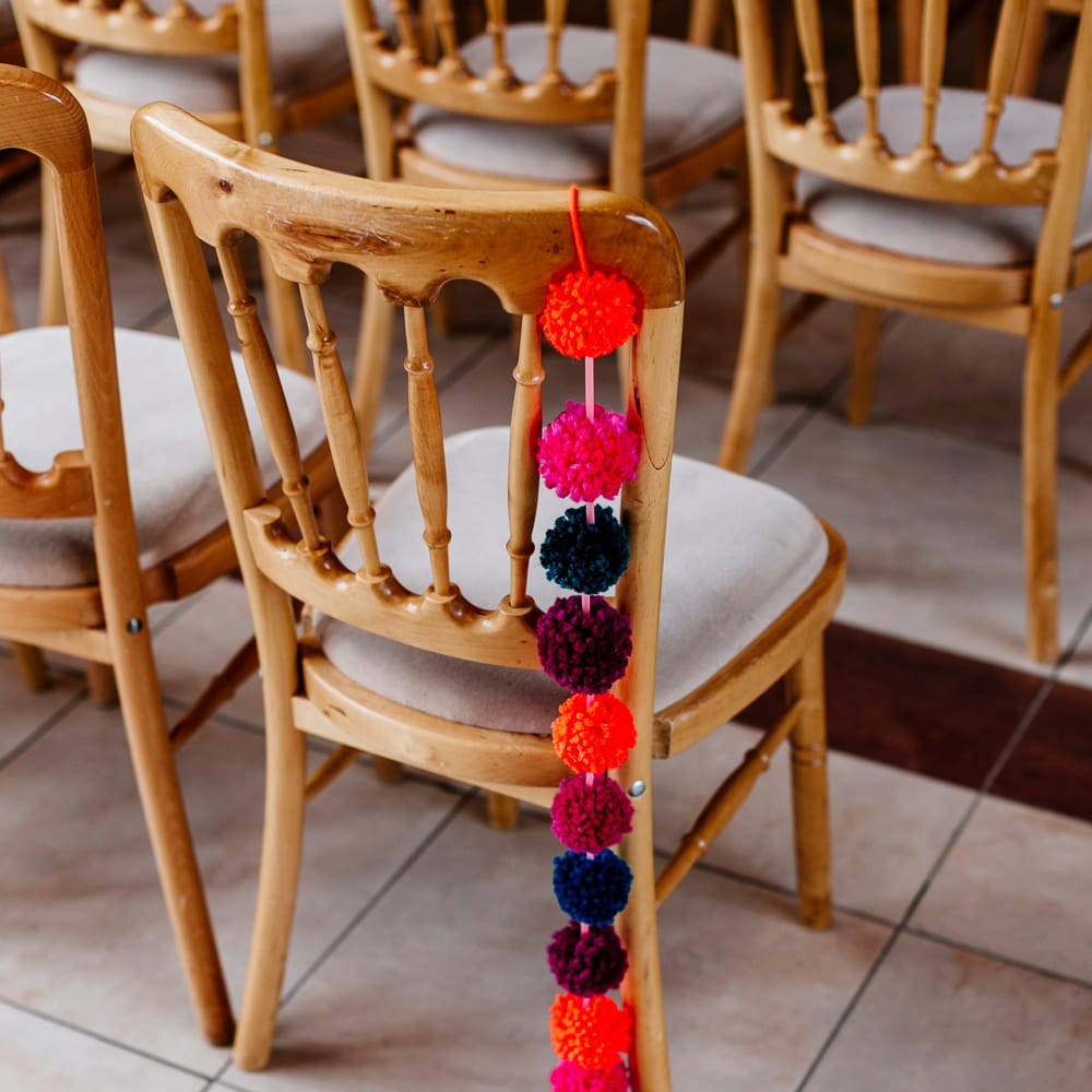Pom Pom Chair Back Decor | Colourful Alternative Winter Wedding at Upwaltham Barns, Sussex | Epic Love Story Photography