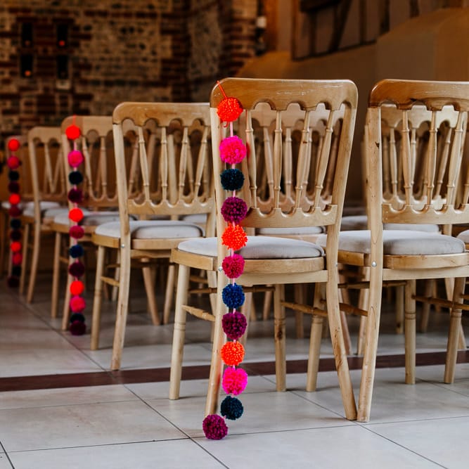 Pom Pom Chair Back Decor | Colourful Alternative Winter Wedding at Upwaltham Barns, Sussex | Epic Love Story Photography