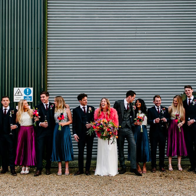 Wedding Party | Bride in Red &amp; White Joanne Fleming Design Wedding Dress | Pink Faux Fur Jacket | Bridesmaids in Jewel Coloured Skirts &amp; Sequin Top Separates | Groomsmen in Suit Supply | Colourful Alternative Winter Wedding at Upwaltham Barns, Sussex | Epic Love Story Photography