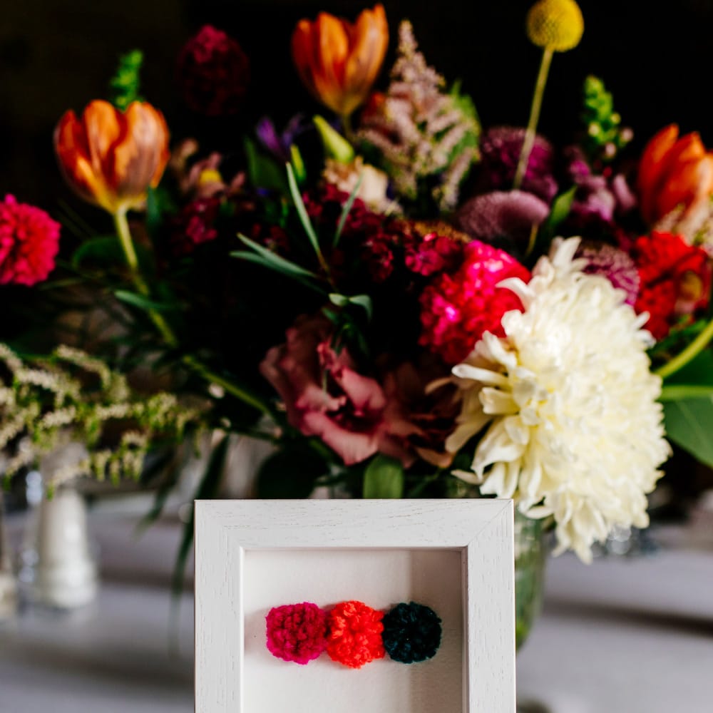 Pom Pom Table Number Sign | Colourful Alternative Winter Wedding at Upwaltham Barns, Sussex | Epic Love Story Photography